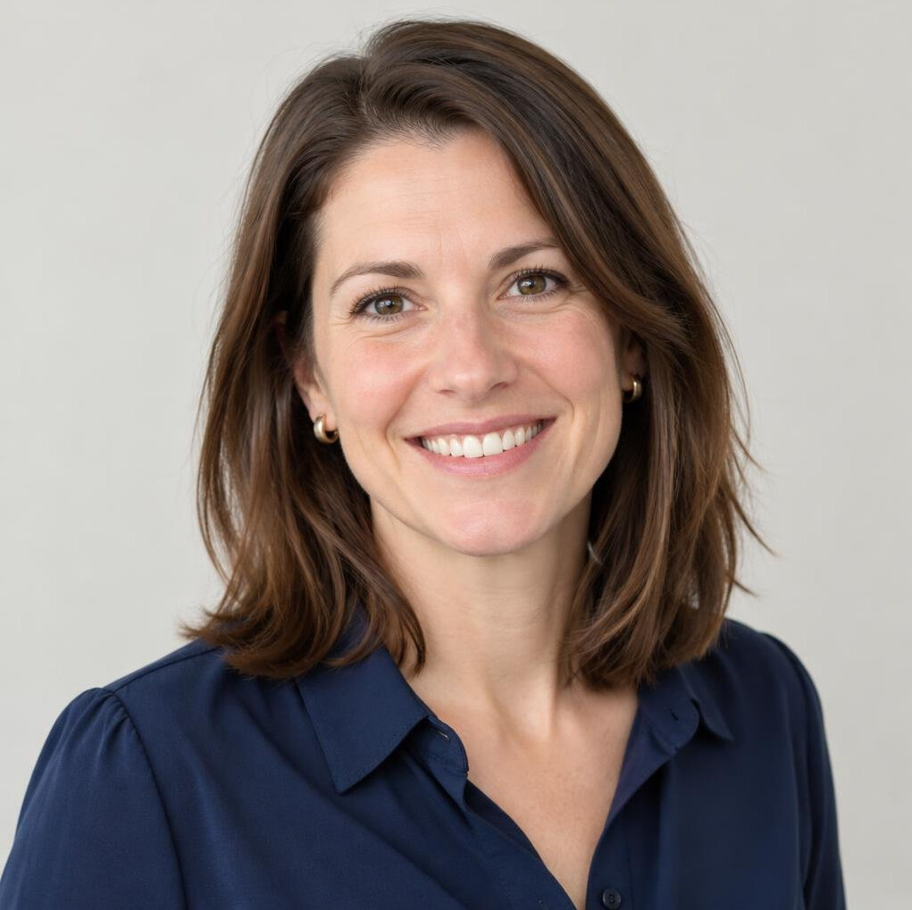 Portrait of a smiling woman with brown hair in a bright setting