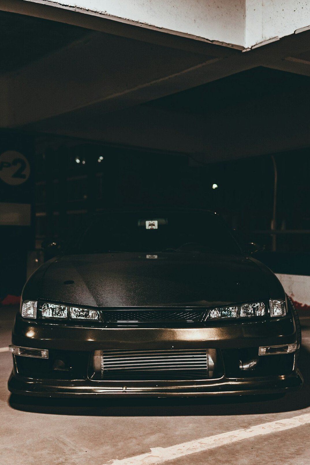 Dark sedan front end with bumper and headlights